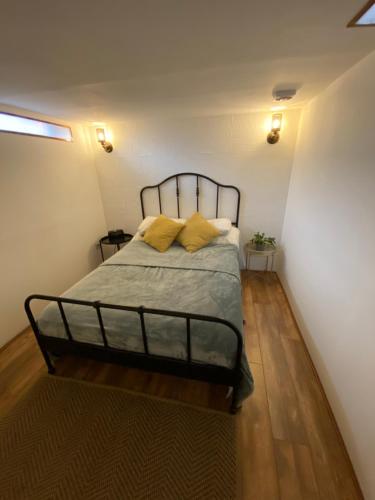 a bedroom with a bed with two yellow pillows at Cute mini-studio in Blythburgh in Blythburgh