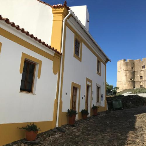 a building with a castle in the background at The Place at Evoramonte in Évora Monte
