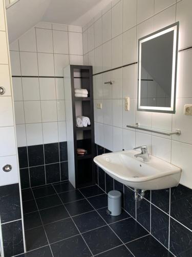 a bathroom with a sink and a mirror at Ferienwohnung am Rothenberg in Altenau