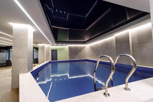 a swimming pool in a building with two faucets at Hilltop North Avenue by Stellar Hotels, Yerevan in Yerevan