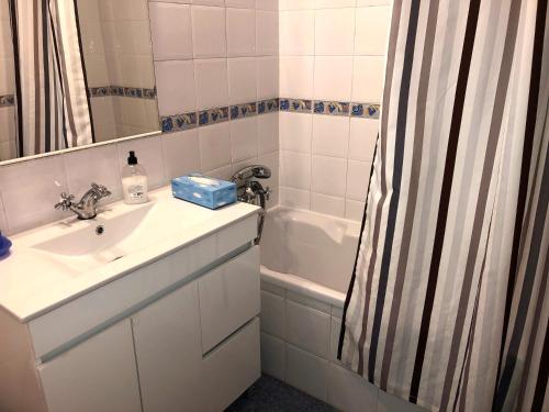 La salle de bains est pourvue d'un lavabo et d'un rideau de douche. dans l'établissement Cliff House next to beach, à Ericeira