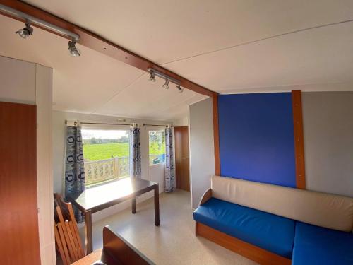 - un salon avec un canapé et un mur bleu dans l'établissement Camping La Baie du Mont Saint Michel, à Céaux