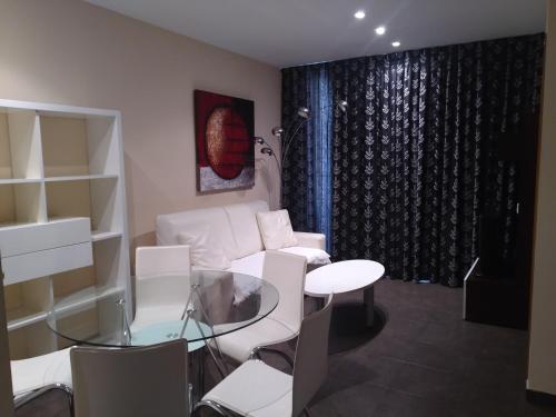 a living room with a white couch and a glass table at Apartamentos Rosi in Benicarló
