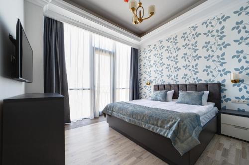 a bedroom with a bed with blue floral wallpaper at Hilltop North Avenue by Stellar Hotels, Yerevan in Yerevan
