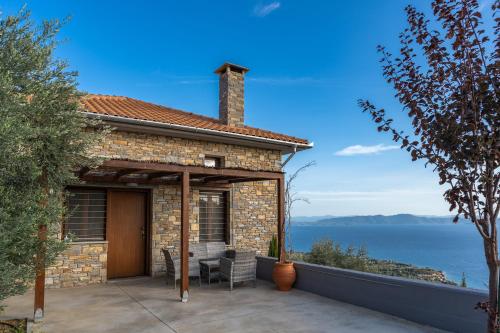 a stone house with a patio with a view of the ocean at Gems of Pinakates in Pinakátai