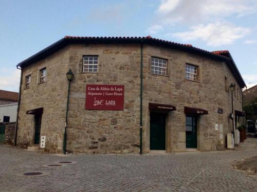 a stone building with a sign on the side of it at Casa Aldeia da Lapa in Sernancelhe
