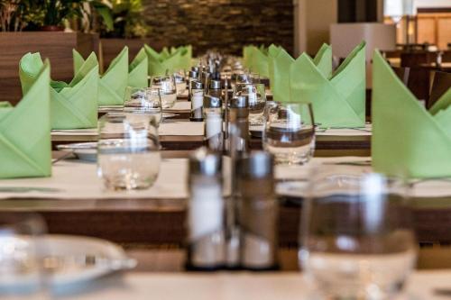 a long table with green napkins and glasses on it at Holiday Inn Budapest-Budaörs by IHG in Budaörs