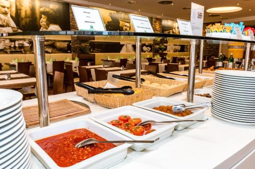 a buffet of food on a counter in a restaurant at Holiday Inn Budapest-Budaörs by IHG in Budaörs