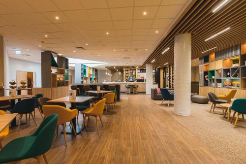 a restaurant with tables and chairs in a cafeteria at Holiday Inn Budapest-Budaörs by IHG in Budaörs
