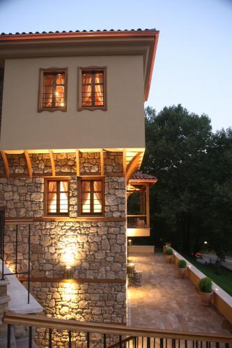a stone house with lights on the side of it at Roes Suites in Kato Loutraki