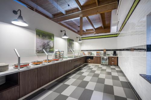 a large kitchen with a checkered floor at enVision Hotel & Conference Center Mansfield-Foxboro in Mansfield