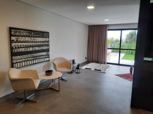 a living room with two chairs and a table at Capão do Cerrado Pousada e Spa in Itabirito