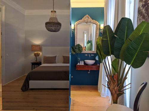 a bedroom with a bed and a mirror and a plant at Palácio do Visconde - The Coffee Experience in Lisbon