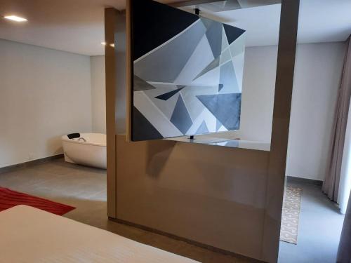 a glass door with a painting on it in a room at Capão do Cerrado Pousada e Spa in Itabirito