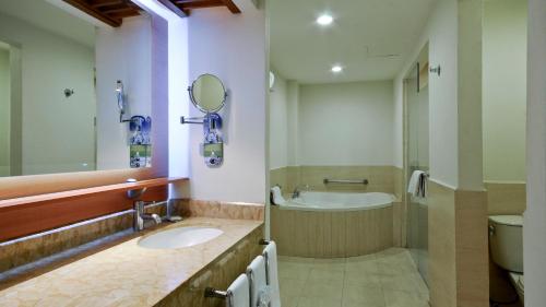 a bathroom with a sink and a tub and a toilet at Holiday Inn Irapuato by IHG in Irapuato