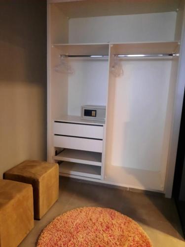 a room with a closet with a stool and a rug at Capão do Cerrado Pousada e Spa in Itabirito