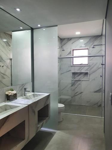 a bathroom with a shower and a sink and a toilet at Capão do Cerrado Pousada e Spa in Itabirito