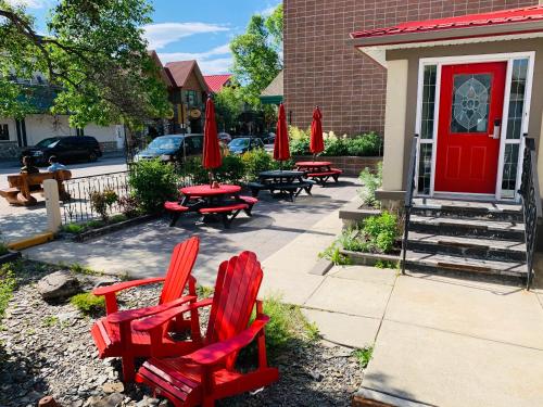 two red chairs and tables in front of a building at Jasper Downtown Hostel in Jasper