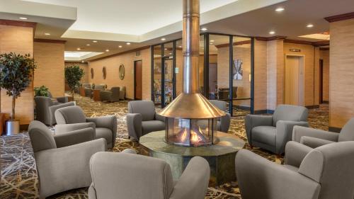 a lobby with chairs and a table with a fireplace at Holiday Inn Denver Lakewood by IHG in Lakewood