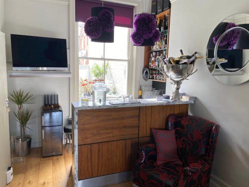 a room with a bar with a chair and a window at Hastings House in Hastings