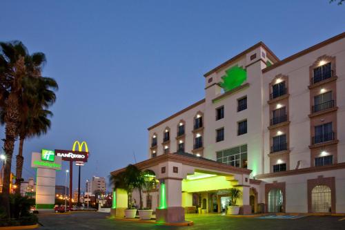 a hotel building with a sign in front of it at Holiday Inn Leon by IHG in León