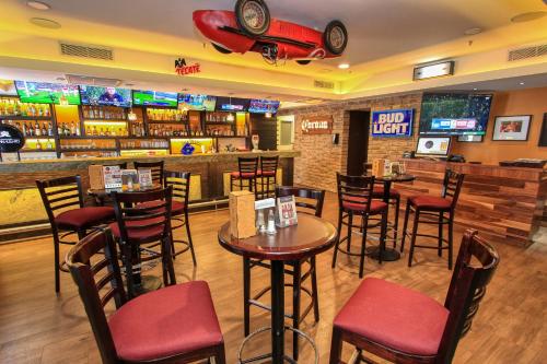a bar with tables and chairs in a restaurant at Holiday Inn Leon by IHG in León