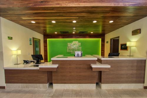 an office with a green wall and a desk at Holiday Inn Leon by IHG in León