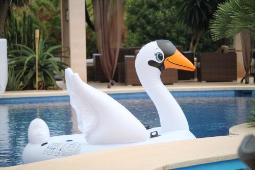 a white swan statue next to a swimming pool at Agroturismo Finca Sa Tanca in Cala d´Or