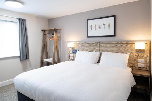 a bedroom with a large white bed and a window at Owl, Hambleton by Marston's Inns in Selby
