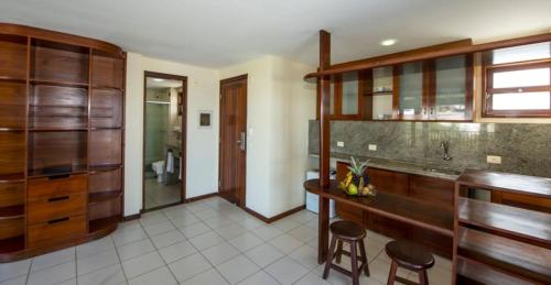 a kitchen with wooden cabinets and stools in a room at Blue Marlin Apartaments Ponta Negra-Natal-RN in Natal