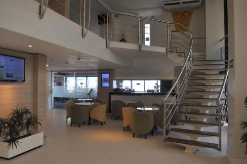 a staircase in a restaurant with tables and chairs at Holiday Inn Fortaleza, an IHG Hotel in Fortaleza