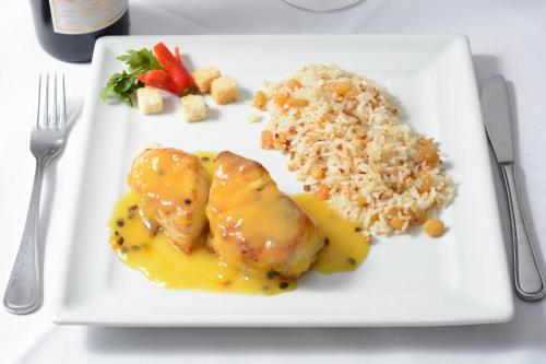 a plate of food with chicken rice and vegetables at Holiday Inn Fortaleza by IHG in Fortaleza