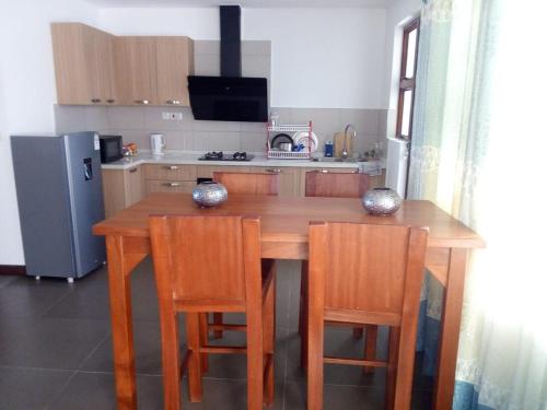 a kitchen with a wooden table with chairs and a refrigerator at Sultan Palace in Kilifi