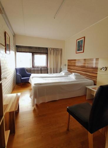 - une grande chambre avec un grand lit et une chaise dans l'établissement Arkadia Hotel & Hostel, à Helsinki