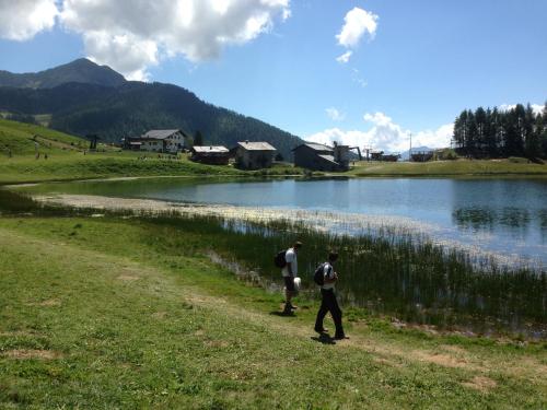 two people walking down a path next to a lake at HOME SWEET HOME in Antey-Saint-André
