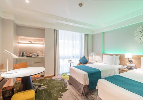 a hotel room with two beds and a table at Holiday Inn Bangkok by IHG in Bangkok