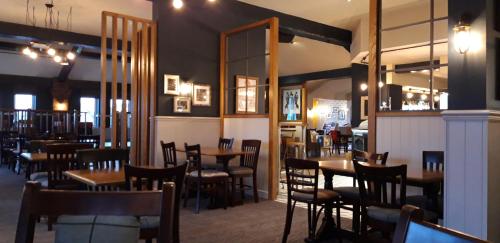 a dining room with tables and chairs in a restaurant at Boundary, Alfreton by Marston's Inns in Alfreton