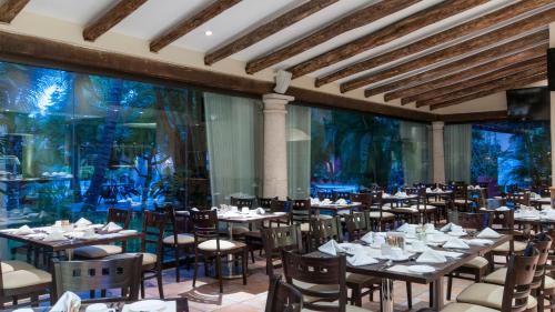 a dining room with tables and chairs and an aquarium at Holiday Inn Ciudad Del Carmen by IHG in Ciudad del Carmen