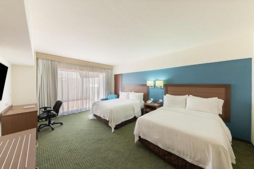 Ένα ή περισσότερα κρεβάτια σε δωμάτιο στο Holiday Inn Guadalajara Expo Plaza del Sol by IHG