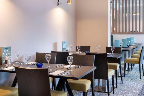 a row of tables and chairs with wine glasses at Holiday Inn Birmingham M6, Jct7 by IHG in Birmingham