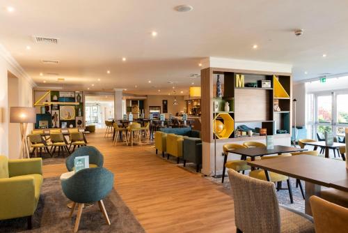 a restaurant with tables and chairs and a bar at Holiday Inn Birmingham M6, Jct7 by IHG in Birmingham