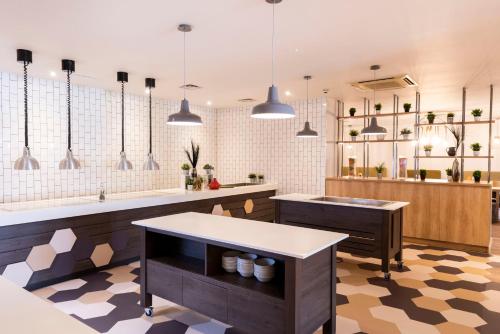 a kitchen with two sinks and a counter with mirrors at Holiday Inn Birmingham M6, Jct7 by IHG in Birmingham