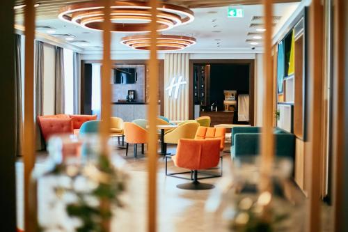 a lobby with chairs and tables in a building at Holiday Inn Krakow City Centre by IHG in Krakow