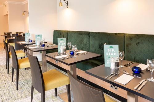 a row of tables in a dining room with chairs at Holiday Inn Birmingham M6, Jct7 by IHG in Birmingham
