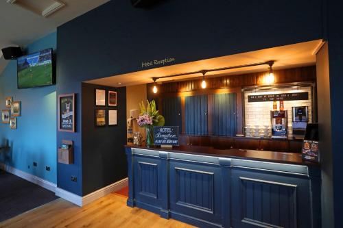 a bar in a restaurant with blue walls at Boundary, Alfreton by Marston's Inns in Alfreton