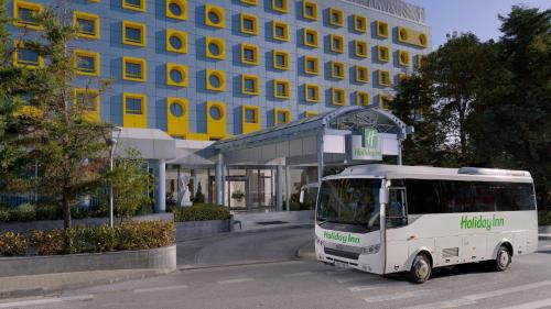 a white truck parked in front of a building at Holiday Inn Athens Attica Av, Airport W. by IHG in Athens