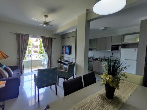 a kitchen and living room with a table and chairs at Bombinhas Centro, apartamento 02 dorm, ótima localização in Bombinhas