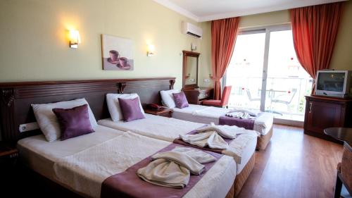 Un pat sau paturi într-o cameră la Alkan Hotel