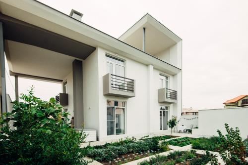 a white house with balconies and a garden at Veronika Home Tbilisi in Tbilisi City