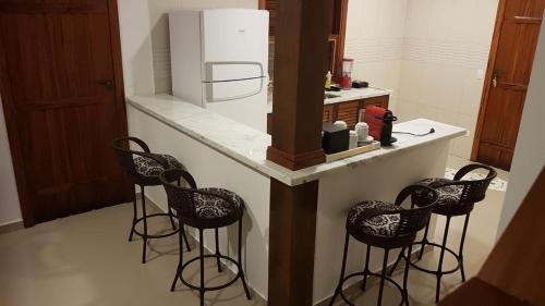 パラチにあるPousada dos Navegantesのキッチン(カウンター、スツール、冷蔵庫付)